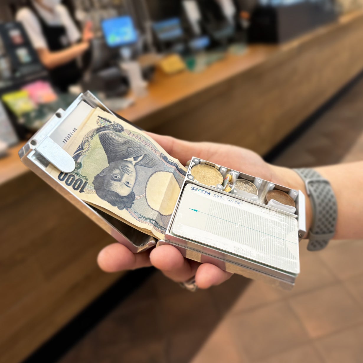 Makuake｜航空機素材のメタルウォレットBoxy パカッと開きお会計シーン